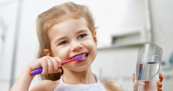 ילדה מצחצחת שיניים